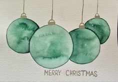 three green christmas ornaments hanging from strings on a white card with the words merry christmas