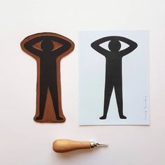 a wooden stamp with a man standing next to a paper cut out of a person