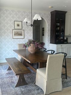 a dining room table with two chairs and a bench