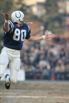 a football player is running with the ball in his hand and people are watching from the stands