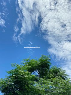 the sky is filled with clouds and green trees