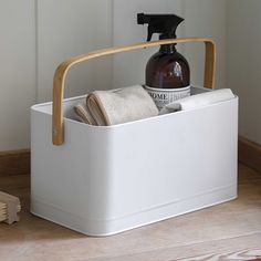 a white container with soap, toothbrush and lotion in it on top of a counter