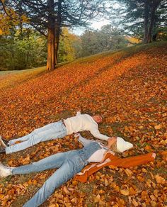 a man laying on the ground next to a woman in a white shirt and jeans