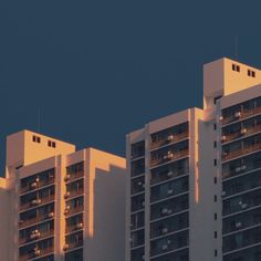 an airplane flying over some tall buildings at night