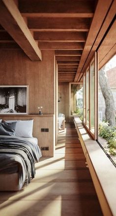 a bedroom with wooden walls and floor to ceiling windows