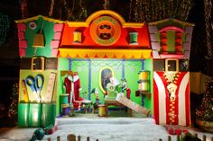 a brightly lit christmas display in front of a building with santa clause decorations on it