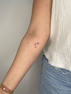 a woman's arm with a small star tattoo on it