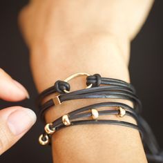 Includes 3 pieces: Raw Eternity Bracelet, Gold Square Bead Bracelet, and Black and Gold Leather Bracelet Trio of our favorite leather bracelets. We are obsessed with these pieces. The more you wear them the softer they get! Lengths: Raw Eternity Bracelet in 14K Gold on Black Leather Cord: 16" (adjustable) Gold Square Bead Bracelet 14K Gold Bead on Black Leather Cord: 12" (adjustable) Black and Gold Leather Bracelet in 14K Gold Filled beads on Black Leather Cord: 27" (adjustable) Hand sculpted an