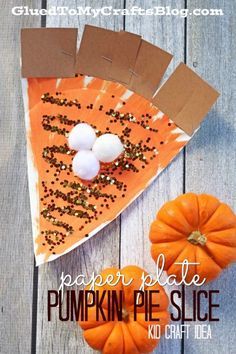 a piece of paper plate pumpkin pie slice on top of a wooden table next to mini pumpkins