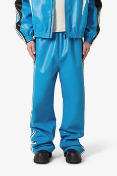 the Icon Oversized PU Track Pants is constructed from a vegan leather fabric, contrast striping details at the outseam, elasticized-self ribbing at the waist, and finished in an oversized, baggy fit. details baggy fit 100% polyester elasticized-self ribbing model is 6’1, 160 lbs and wears a size medium Casual Straight Leg Leather Pants For Streetwear, Blue Bottoms With Contrast Stitching For Fall, Blue Pants With Contrast Stitching For Spring, Spring Blue Pants With Contrast Stitching, Blue Relaxed Fit Pants With Contrast Stitching, Blue Pants With Contrast Stitching, Relaxed Fit, Sporty Pants With Contrast Stitching For Streetwear, Sporty Streetwear Pants With Contrast Trim, Sporty Pants With Contrast Trim For Streetwear