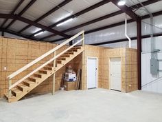 the inside of a building that is being built with wooden walls and stairs in it