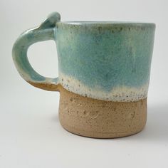 a blue and white coffee cup sitting on top of a table