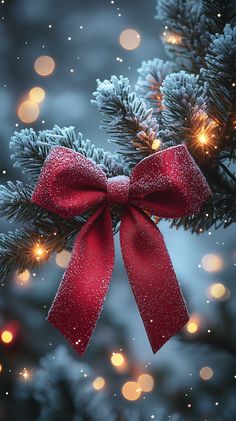 a red bow hanging from the side of a christmas tree with lights in the background