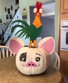 a pumpkin shaped like a mouse with a rooster on top