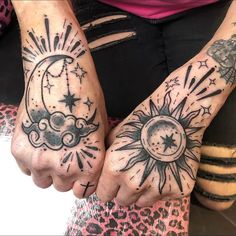 two hands with sun and moon tattoos on them