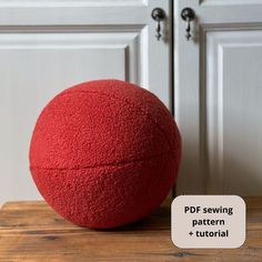 a red ball sitting on top of a wooden table