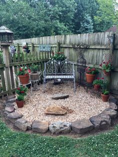 a garden area with rocks and plants in the center, surrounded by wooden fence posts