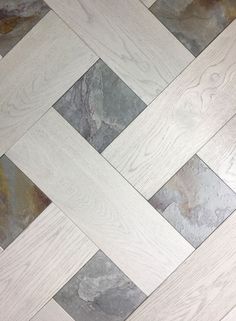 the floor is made from wood and has grey and white tiles on top of it