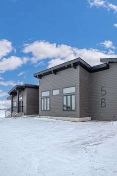 a building with snow on the ground and blue sky in the backgrouds