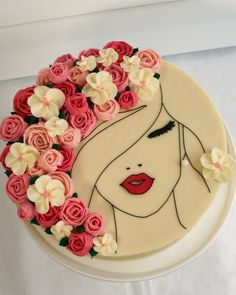 a cake decorated with flowers and a woman's face