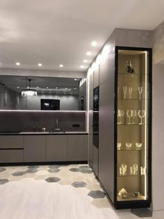 a modern kitchen with glass shelves and stainless steel appliances in the center is lit by recessed lights