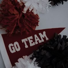 some tissue pom poms are sitting on top of a red and white sign