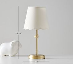 a white elephant lamp sitting next to a table with a light on it's side