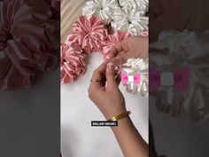 the woman is doing something with her hand and some fabric flowers on top of it