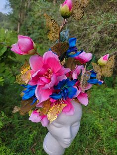 This floral headdress feature bright blue and pink flowers and gold butterflies. It is tall but suprisingly light and features a comb under the headband base to keep it extra secure. Multicolor Spring Headband, Multicolor Headband For Spring, Whimsical Pink Headpiece For Garden Party, Pink Flower Hair Accessories For Summer, Adjustable Multicolor Headpieces For Spring, Whimsical Multicolor Headpieces For Spring, Whimsical Pink Headpieces For Spring, Pink Hair Accessories With Handmade Flowers For Summer, Whimsical Flower Hair Accessories For Spring