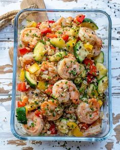 a glass dish filled with shrimp and vegetables