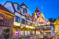 a row of colorful buildings with lights on them at night in the town square stock photo