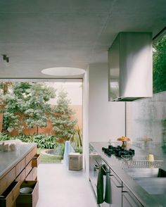 a modern kitchen with stainless steel appliances and wood cabinetry, along with an outdoor dining area