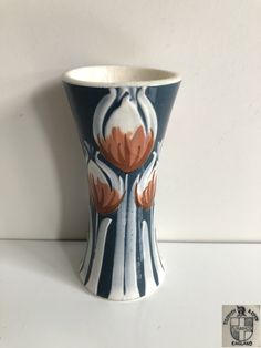 a blue and white vase with flowers painted on it