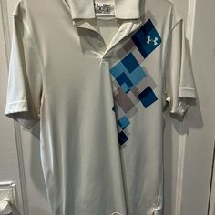 Gently Worn Under Armour Mens Golf/Lifestyle Polo. Comes From Smoke Free Home And Is Nearly Brand New Condition. White Polo Collar Golf Shirt, White Polo Collar Golf Top, White Polo Collar Top For Golf, Under Armour White T-shirt With Graphic Print, White Under Armour T-shirt With Graphic Print, White Crew Neck Golf Shirt, White Golf Shirt With Graphic Print, White Graphic Print Shirt For Golf, Golf Lifestyle