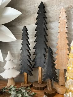 three wooden christmas trees sitting on top of a table