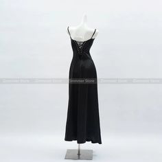 a black dress on display in front of a white background