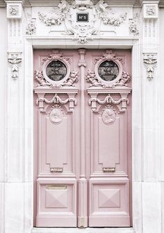 a pink door with ornate carvings on it