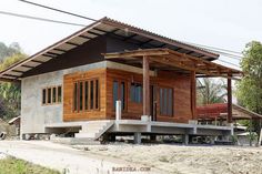 a small wooden house sitting on top of a dirt road