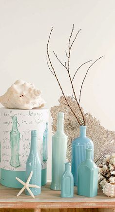 blue bottles and seashells sit on a shelf next to a starfish sculpture