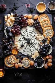 a table topped with crackers, grapes and cheese