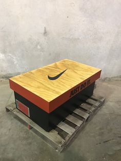 a box sitting on top of a pallet with the word nike painted on it