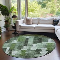 a living room with a white couch and large green rug on the floor in front of a window