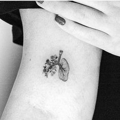 a black and white photo of a woman's arm with a flower tattoo on it