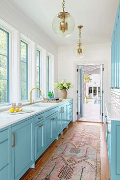 a kitchen with blue cabinets and an area rug