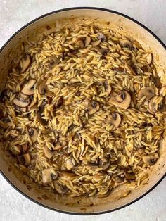 a pot filled with rice and mushrooms on top of a table