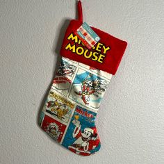 a christmas stocking hanging on the wall with mickey mouse pictures and comic strip designs