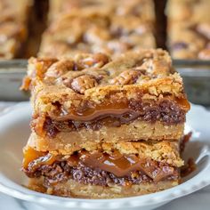 a stack of dessert bars sitting on top of a white plate