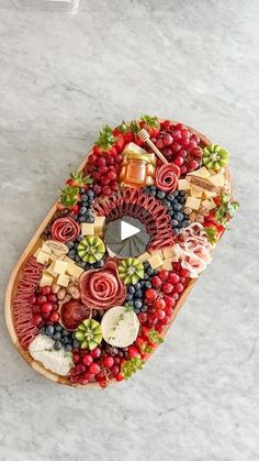 an overhead view of a platter with fruit, cheese and crackers on it