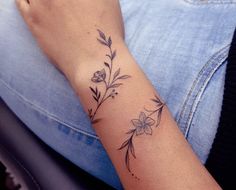 a woman's arm with a flower tattoo on the left side of her wrist