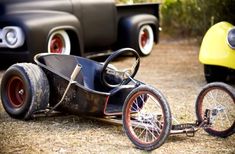 an old fashioned pedal car is on the ground